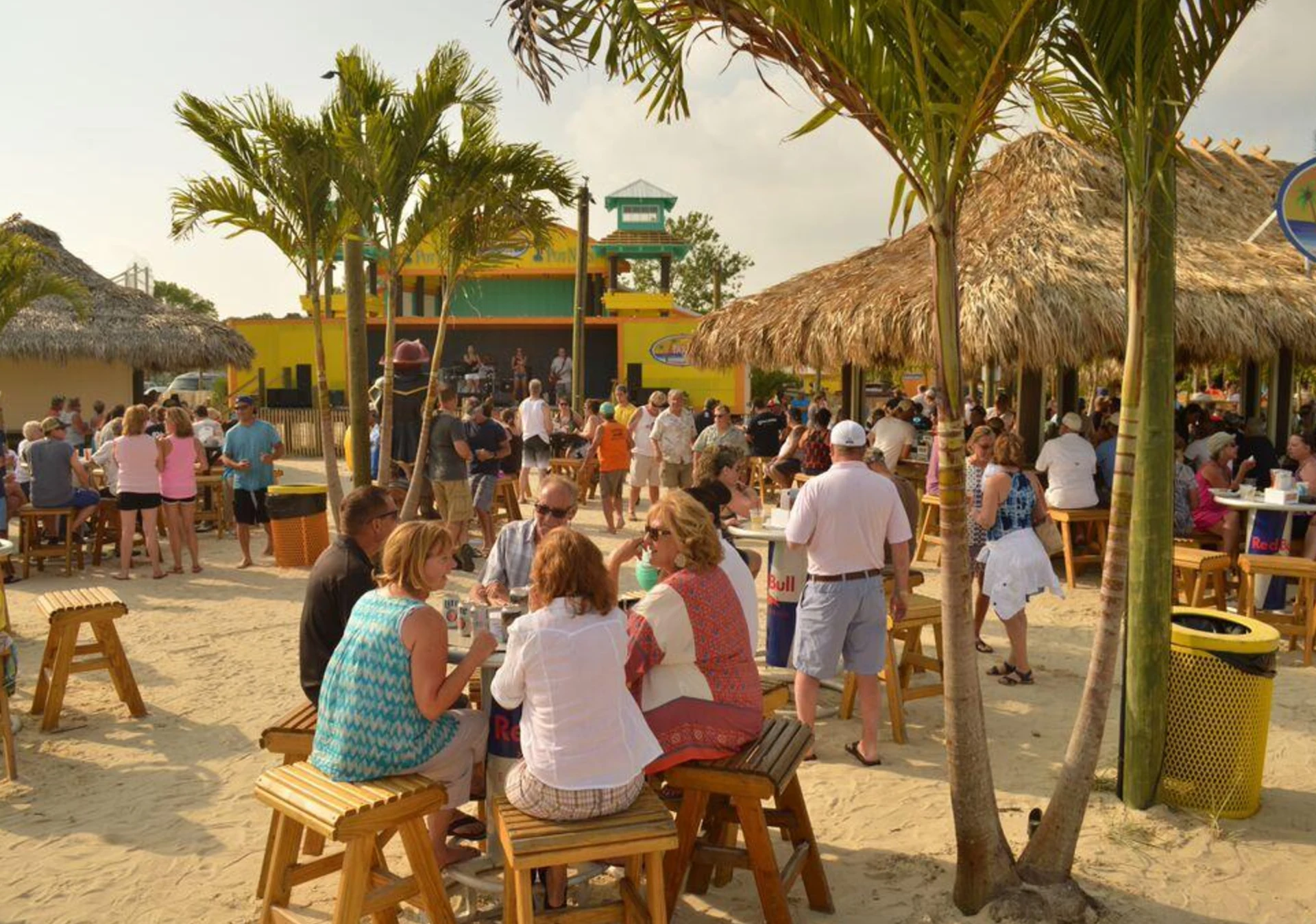 Guests gathering around Paradise Grill’s thatched tiki bars